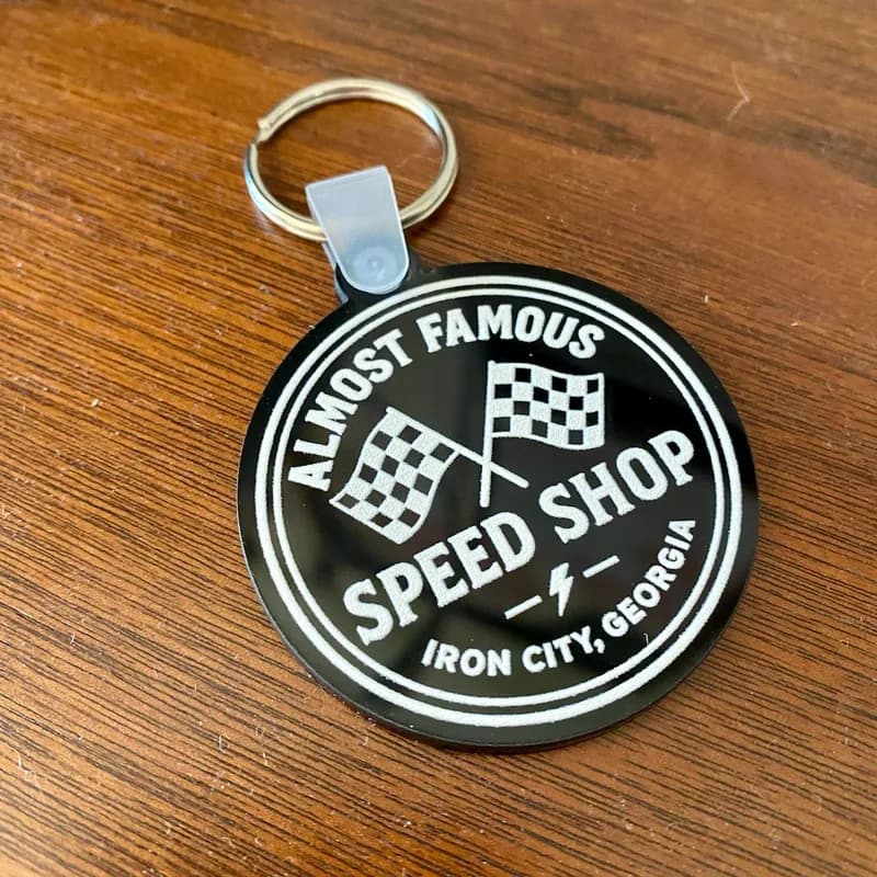 Almost Famous Speed Shop round black acrylic keychain